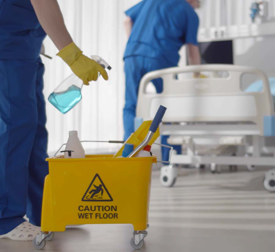 Environmental services staff cleaning hospital room.